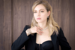 Studio portrait of a woman wearing jewelry against a wooden background