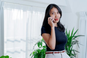 A woman making a phone call in an office.