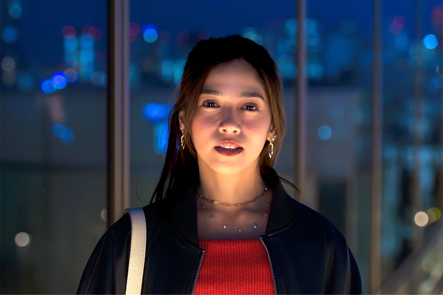 Headshot of a girl on the rooftop of the Shibuya Parco Department Store at night.