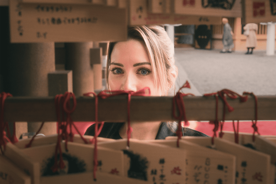 Close-up on a woman's eyes staring at the lens in a Japanese shrine