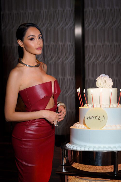 Mandarin Oriental hotel event photo of woman in red leather dress standing beside birthday cake with Japanese text