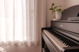 Piano in the Bedroom A close-up of a piano in a softly lit room with a small plant on top, creating a serene and artistic atmosphere.