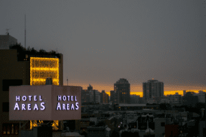 City View at Sunset from the Studio Balcony A city view at sunset with a prominent "Hotel Areas" sign illuminated on a building.