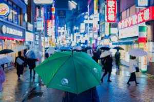 A green umbrella stands out in the neon-lit streets of Shibuya for Miry Brook Technologies.