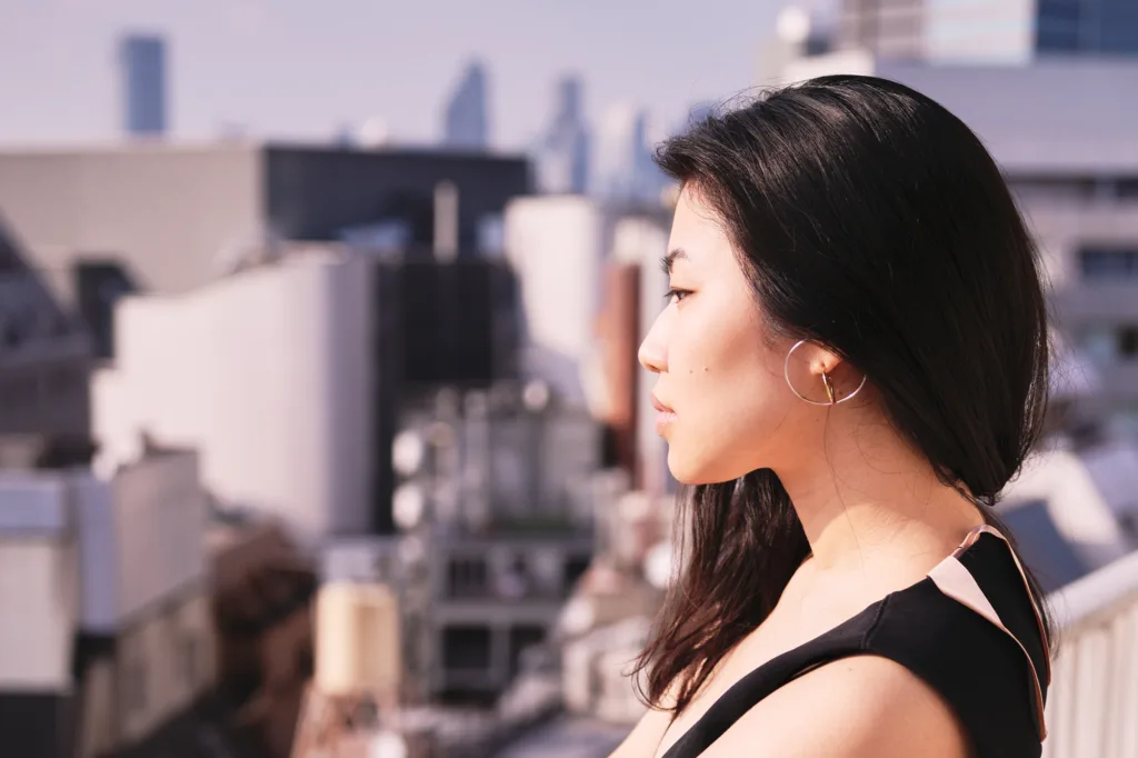 モデル・ユリコがスタジオのベランダから新宿の景色を望む JG Studioのベランダで新宿の景色を背にポーズをとるプロモデル・ユリコ。次回の撮影は当スタジオで予約ください。