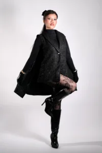 Professional high fashion portrait of a model in a black vest, turtleneck, and fishnet stockings, posing in a Tokyo photo studio by JG Studio.