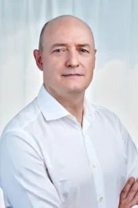 A corporate portrait of a businessman in a white shirt, taken in a professional photography studio in Tokyo.