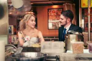 A wedding couple enjoys a candid moment at a local food stall during a photo tour in Shimokitazawa, Tokyo.