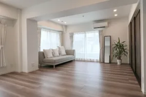 渋谷・道玄坂にあるJG Studioのメインルーム。大きな窓から自然光が差し込む、グレーのソファとベランダのある開放的な空間。