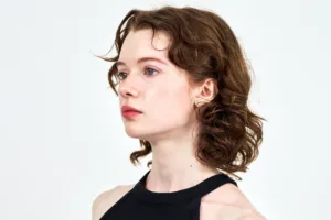 Elegant woman profile portrait with wavy hair in black top, fashion photography by JG Brasseur Tokyo.