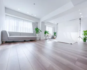 A 2.2m-wide white seamless backdrop set up at JG Studio in Shibuya. A sun-drenched shooting space featuring hardwood floors and a gray sofa.