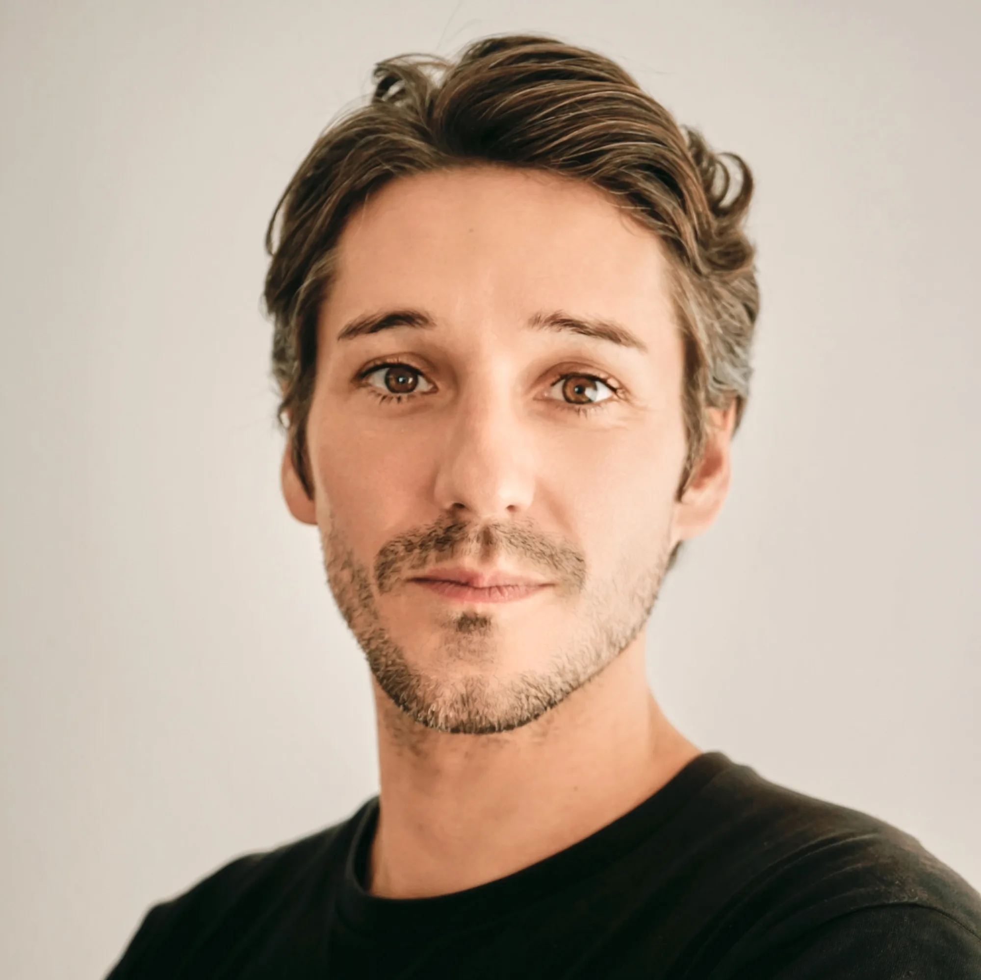 JG (Jean-Guillaume Brasseur), French portrait and corporate photographer based in Tokyo, photographed in natural light against a pale grey background.