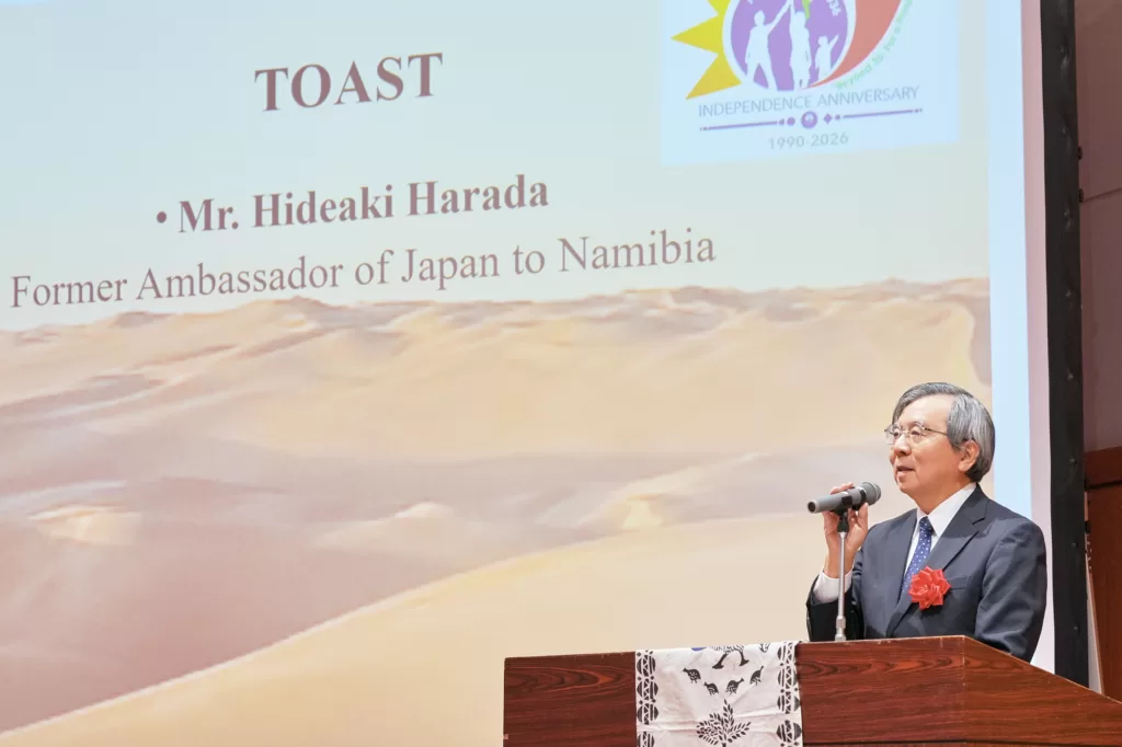 東京のナミビア独立記念レセプションで、スクリーンの前で乾杯の挨拶をする元駐ナミビア日本大使。